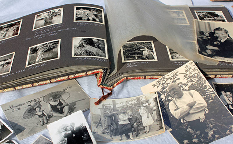 Aufgeschlagene Seite eines Fotoalbums mit Schwarz-Weiß-Bildern