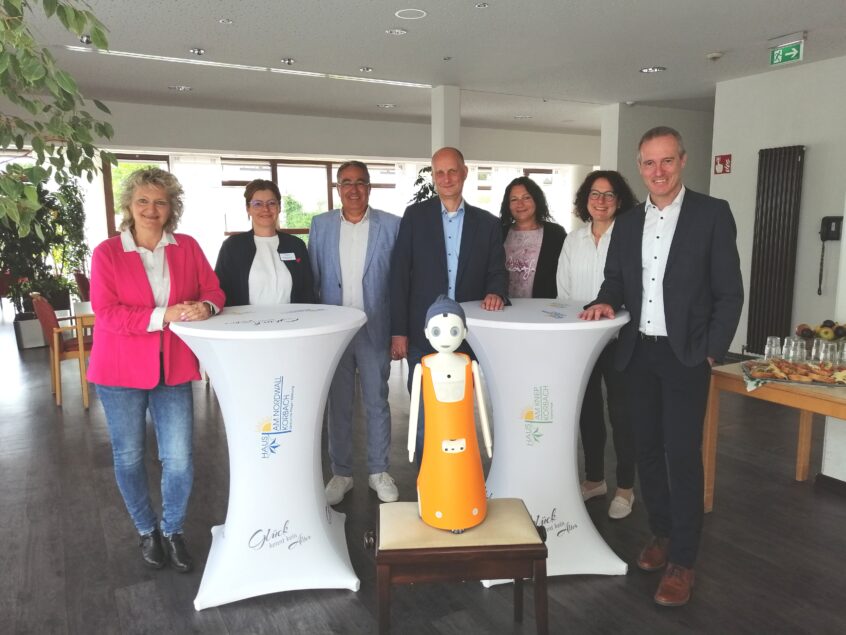 Roboter Leo stellte sich im „Haus am Nordwall“ dem Bürgermeister und dem Landrat vor. (v.l.n.r.) Martina Schäfer, Sachbearbeitung Waldeckische Landesstiftung/ Waldeckische Domanialverwaltung; Ribana Klabunde, Einrichtungsleiterin „Haus am Nordwall“; Sassan Pur Kassalian, Geschäftsführer „Haus am Nordwall“; Bürgermeister Stefan Kieweg; Agnes Schmidt, Pflegedienstleitung „Haus am Nordwall“; Claudia Schneider, Qualitätsmanagement „Haus am Nordwall“; Landrat Jürgen van der Horst; (vorne) Roboter Leo Foto: Landkreis Waldeck-Frankenberg