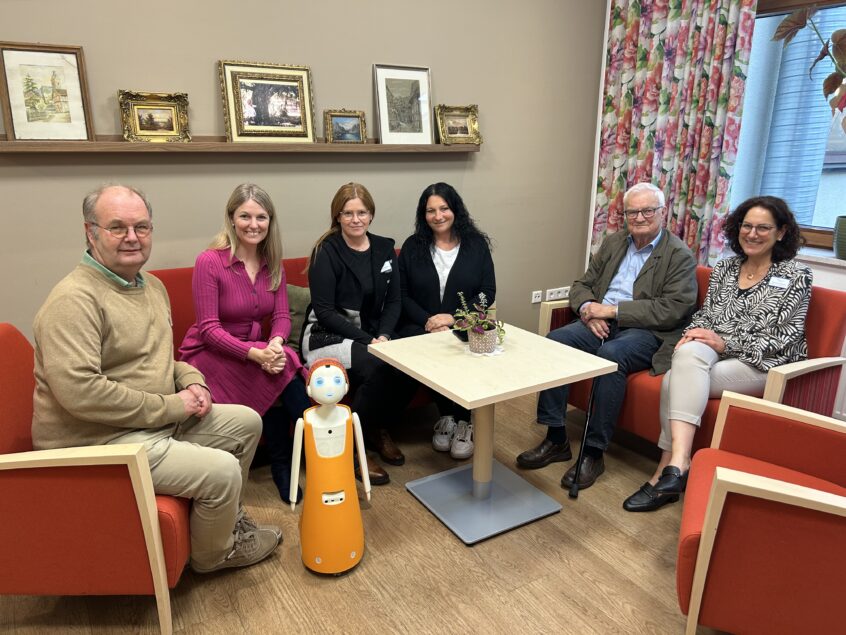 Ralf Wittwer, Kathrin Anders, Leitungsteam Haus am Nordwall und Einrichtungsbeiratsvorsitzender Karl Heinz Welteke in Interaktion mit Sozialroboter Leo