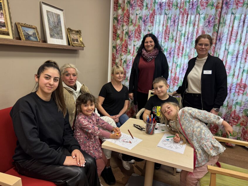 Kinder, Mütter und Initiatoren des Betreuungsangebots beim Malen und Spielen